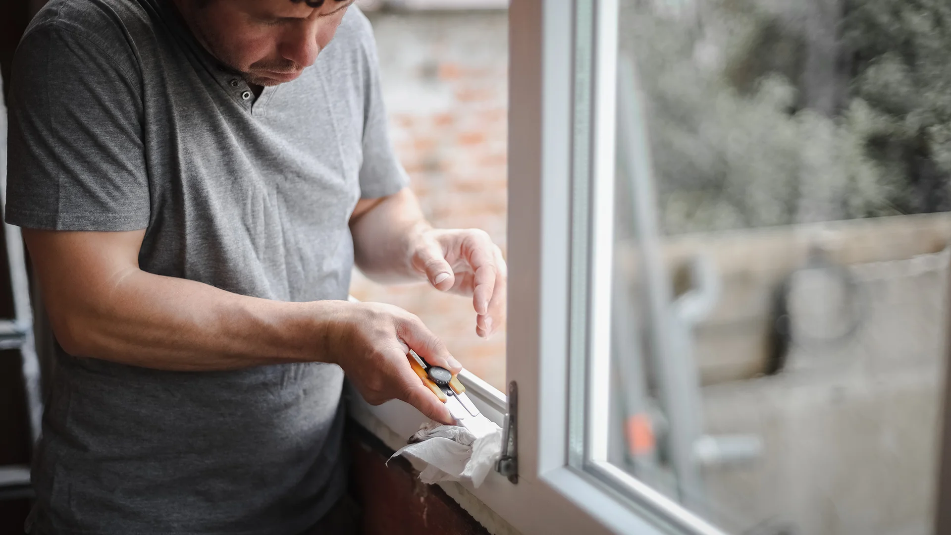 man-cleans-window-frame