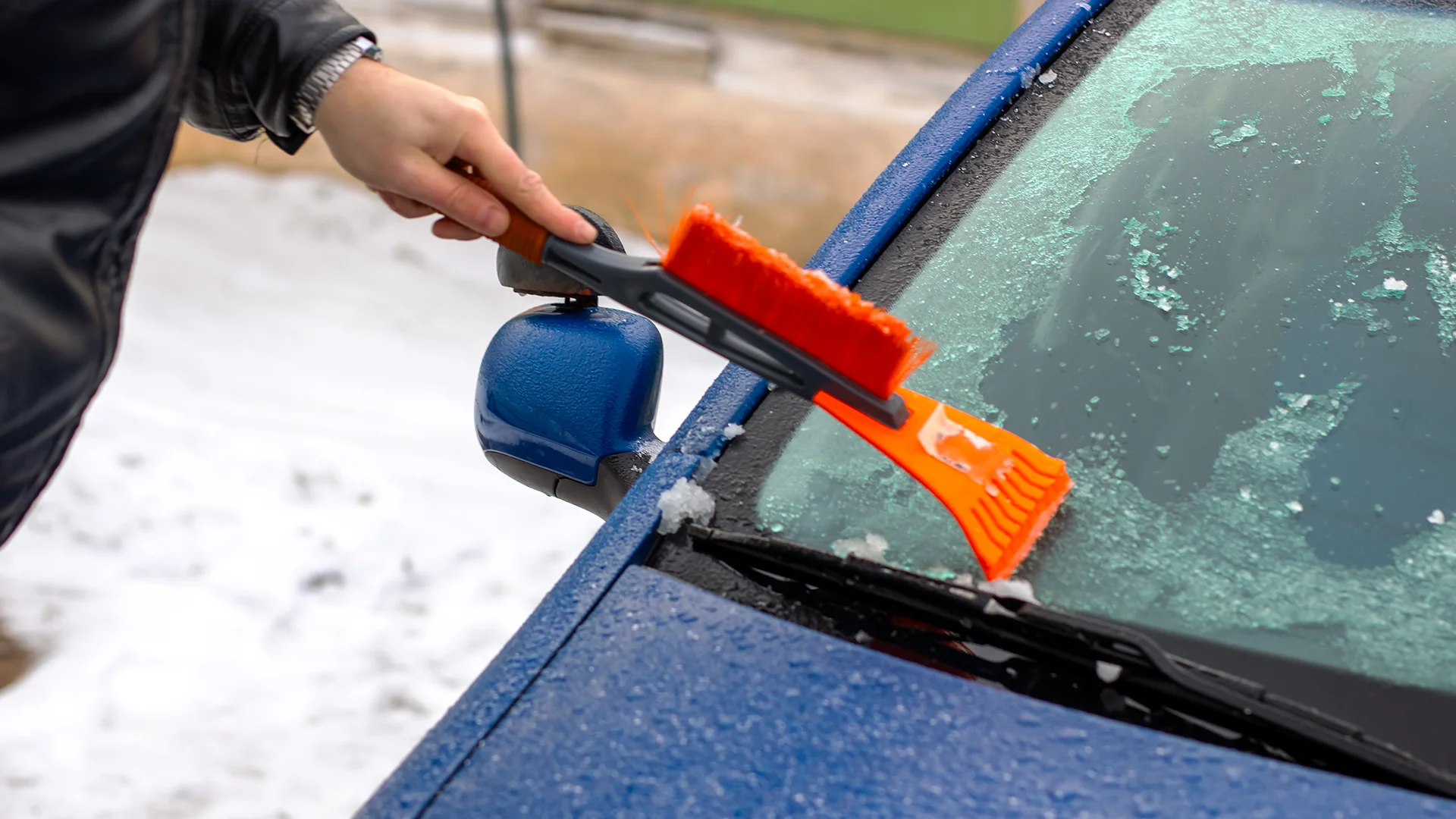 person is cleaning the cars windshield