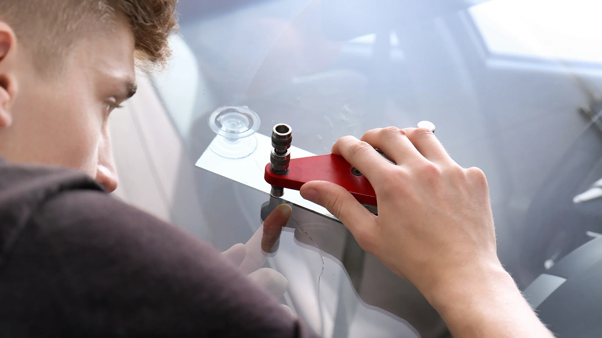 Specialist fixing crack on car windshield